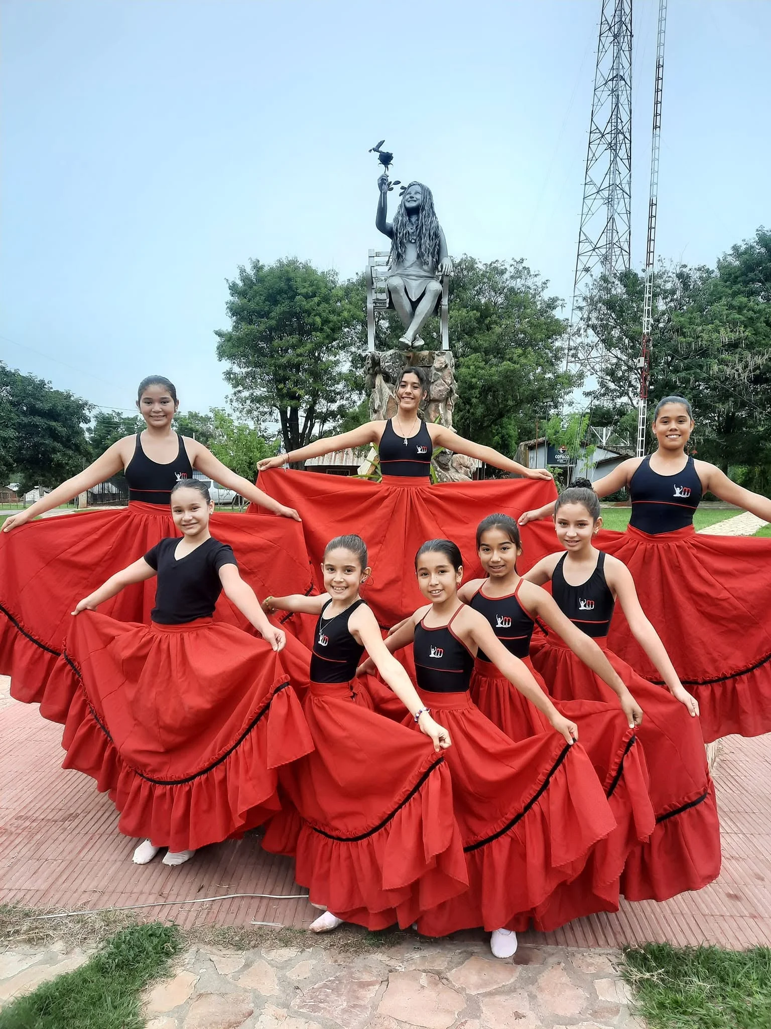 Grupo de bailarinas del estudio con faldas rojas al aire libre